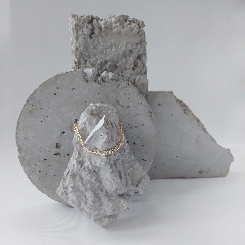 Betonstein Fotografie Requisiten mit tiefer Textur und geometrischen Formen, Goldene Kette als Styling Beispiel Betonstein Fotografie Requisiten mit tiefer Textur und geometrischen Formen, Goldene Kette als Styling Beispiel