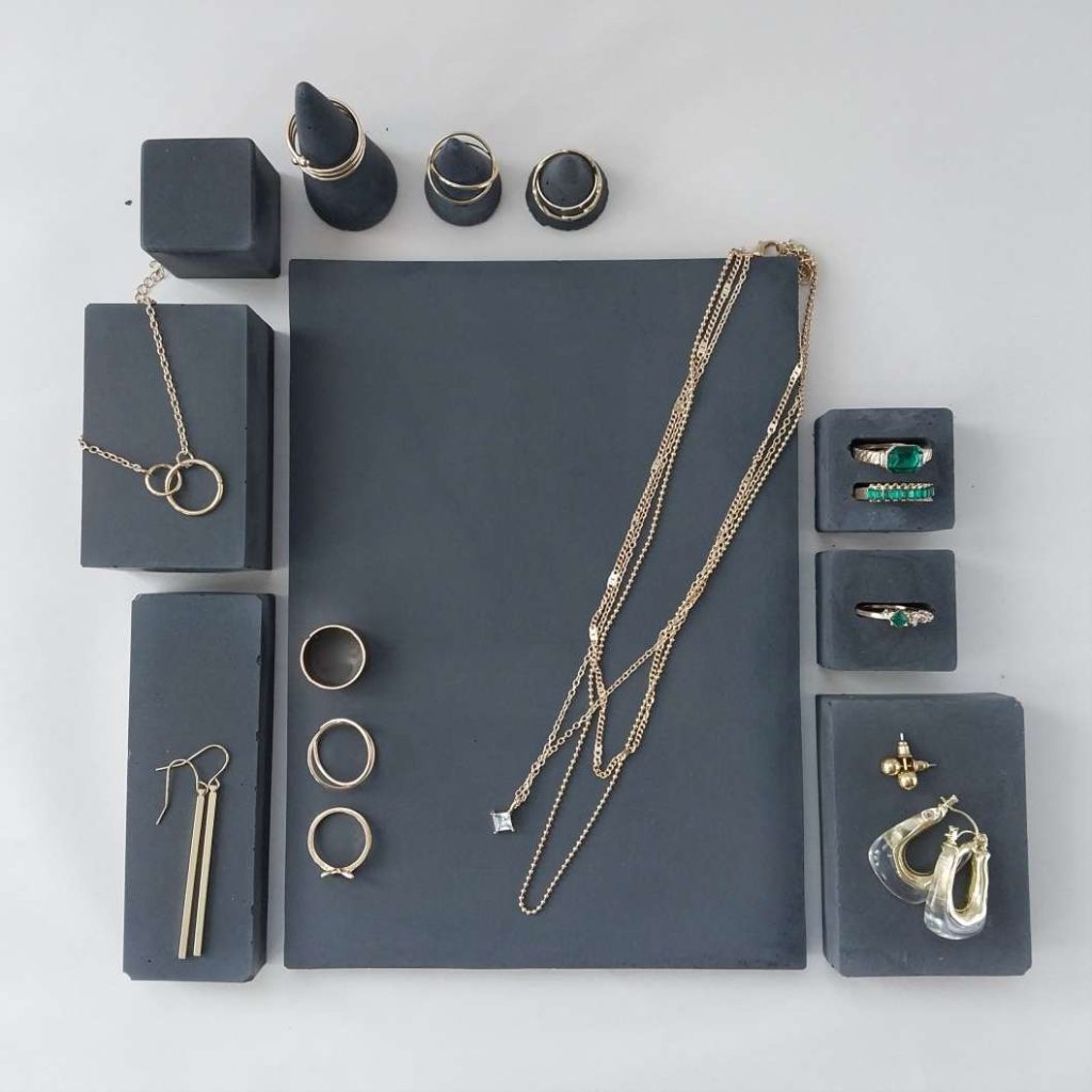 Schmuckpräsentation, dunkelgrauer Beton in geometrischen Formen Schmuckpräsentation, dunkelgrauer Beton in geometrischen Formen mit Beispielschmuck