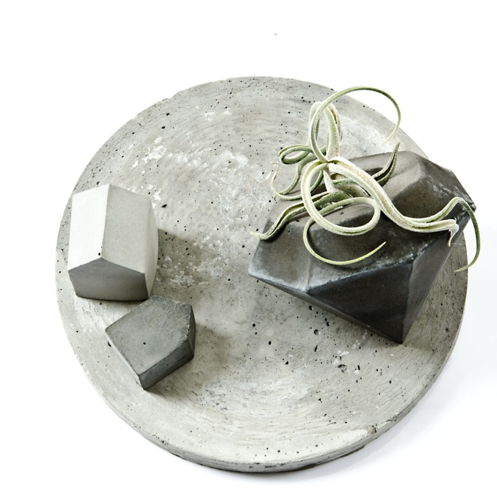 Rundes Beton Tablett dekoriert mit zwei kleinen beton Häuschen und einem Diamant Air Plant Holder