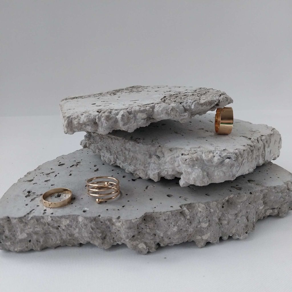 Textur Beton Stücken gestapelt zur Präsentation mit Goldschmuck
