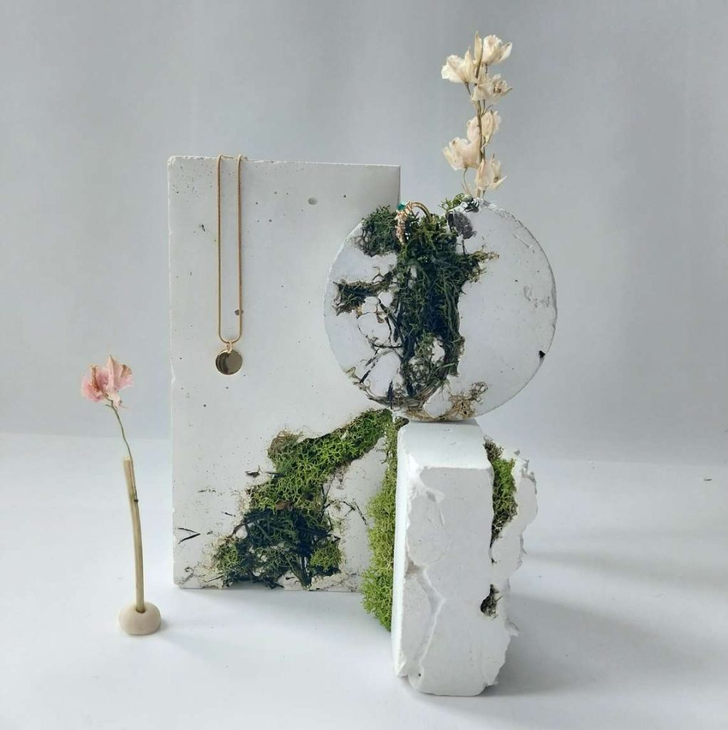 Weisser Texturebeton mit grünem Moos in geometrischen Formen als Schmuckdisplay, Schaufensterauslage oder Fotohintergrund. Weisser Texturebeton mit grünem Moos in geometrischen Formen als Schmuckdisplay, Schaufensterauslage oder Fotohintergrund.